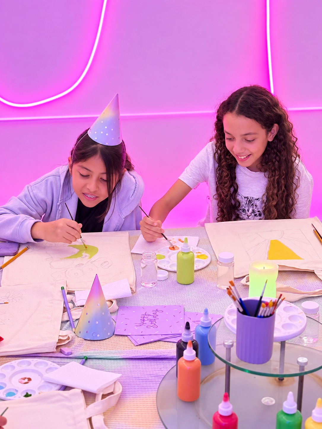 Dos niñas pintando tote bags durante una fiesta privada en Art D'ler
