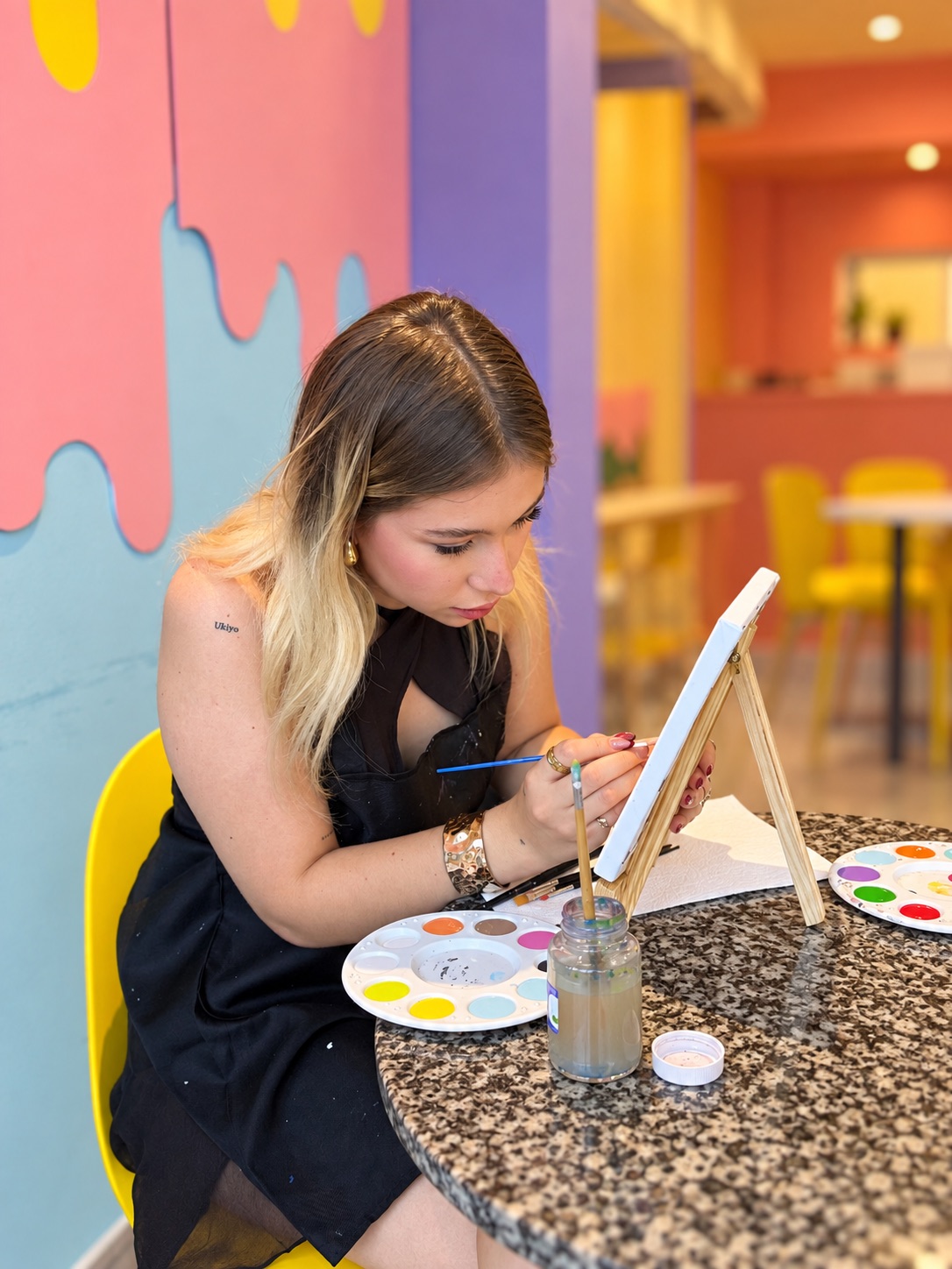Joven pintando un lienzo sobre un caballete en Art D'ler